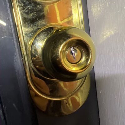 Brass door knob with broken key stuck in keyhole